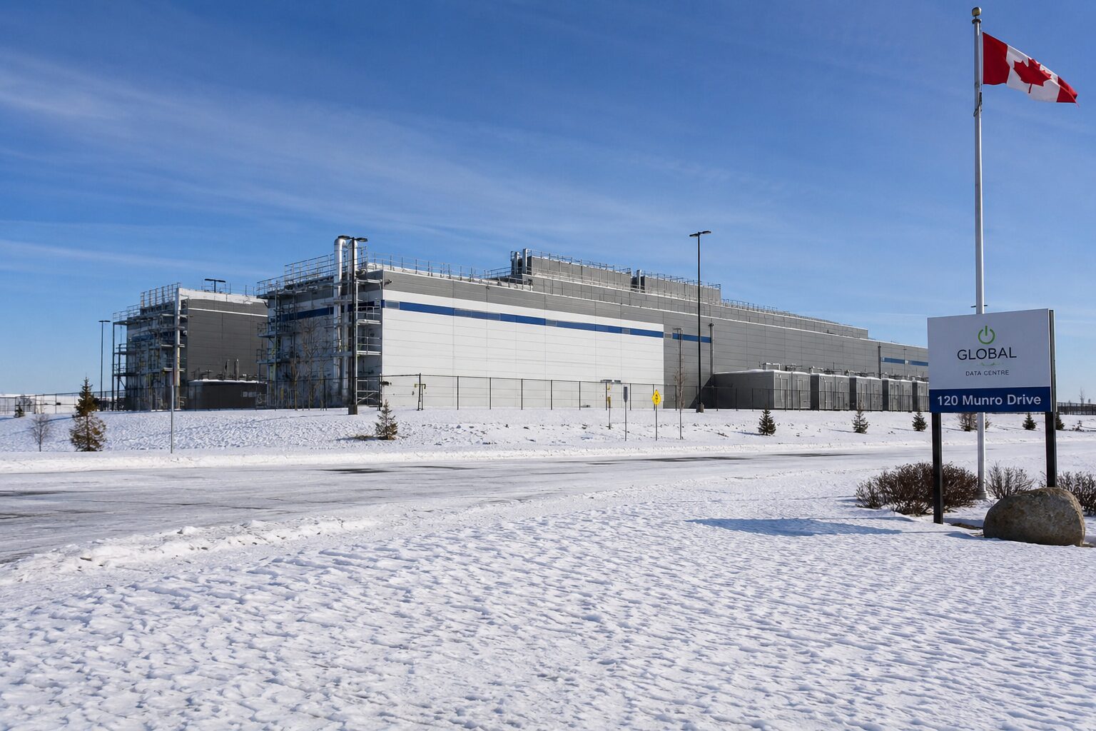 Bitwrx northern data hall facility with Canadian flag, expansive paved approach and clear blue skies
